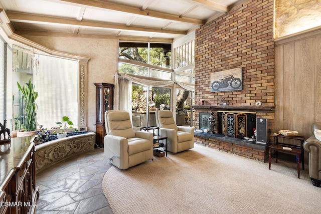 living room with beamed ceiling, wooden walls, and a brick fireplace