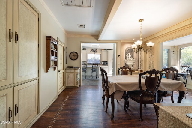 dining room with dark wood-type flooring, crown molding, and an inviting chandelier