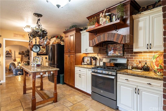 kitchen featuring decorative light fixtures, dark stone countertops, decorative backsplash, and appliances with stainless steel finishes