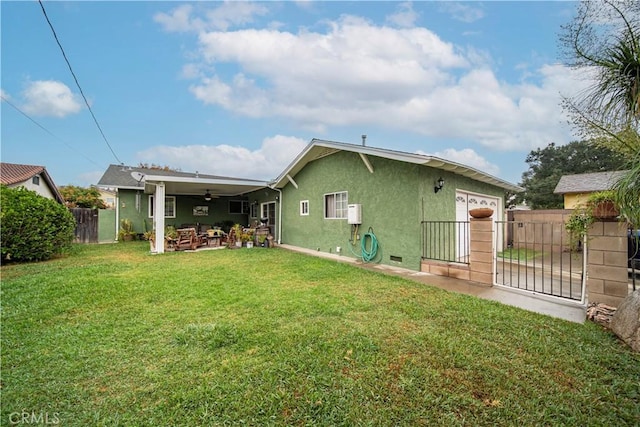 back of property featuring outdoor lounge area, a yard, and ceiling fan