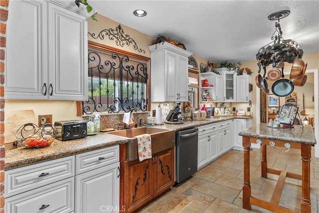 kitchen featuring white cabinets, dishwasher, light stone countertops, and sink