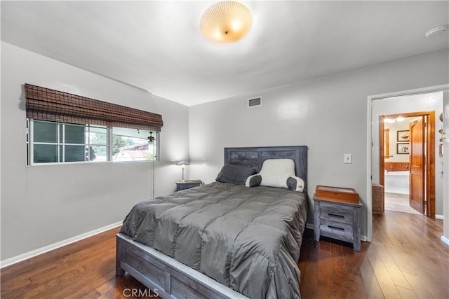 bedroom with dark hardwood / wood-style flooring and connected bathroom