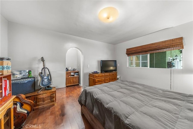 bedroom featuring connected bathroom and hardwood / wood-style flooring