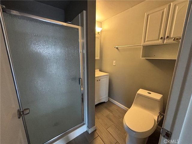 bathroom featuring toilet, wood-type flooring, vanity, and an enclosed shower