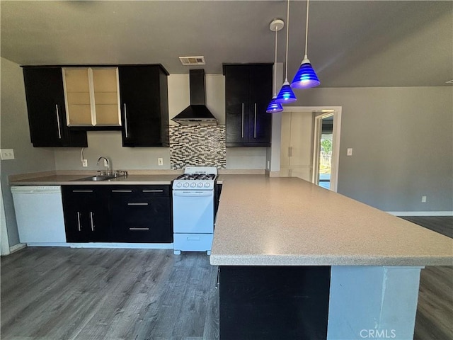 kitchen with decorative light fixtures, tasteful backsplash, sink, white appliances, and wall chimney exhaust hood