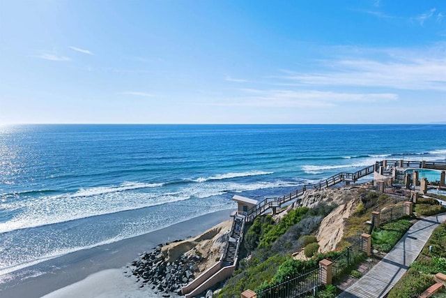 birds eye view of property with a water view and a beach view