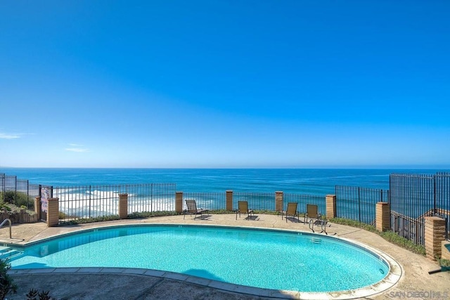 view of swimming pool with a water view and a patio