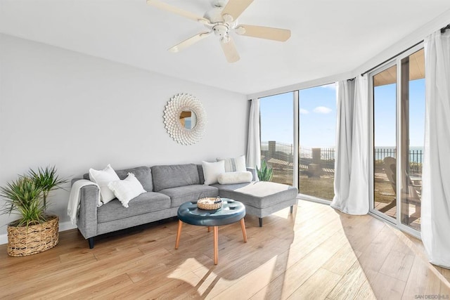 living room with light hardwood / wood-style flooring, expansive windows, and ceiling fan