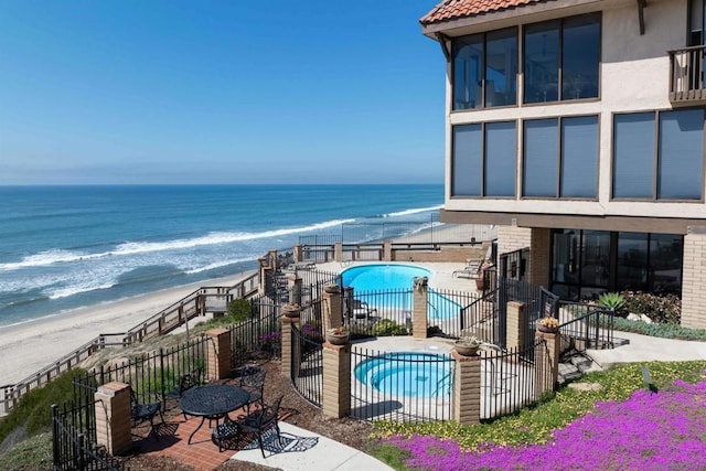 balcony featuring a water view, a patio, and a view of the beach