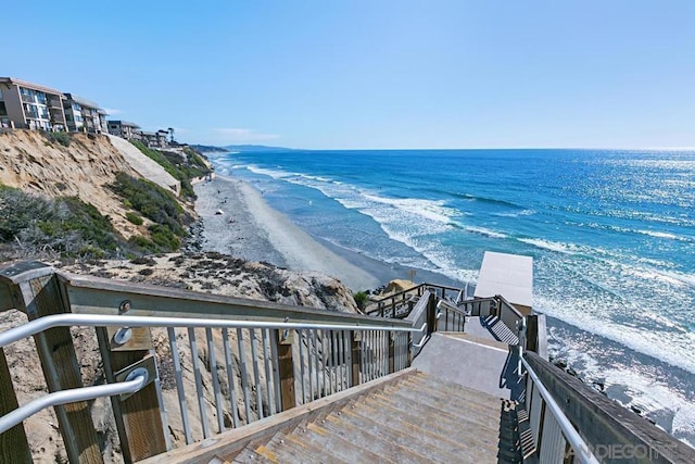 view of mountain feature featuring a water view and a beach view