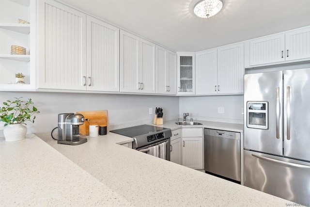 kitchen featuring light stone counters, white cabinetry, sink, and appliances with stainless steel finishes