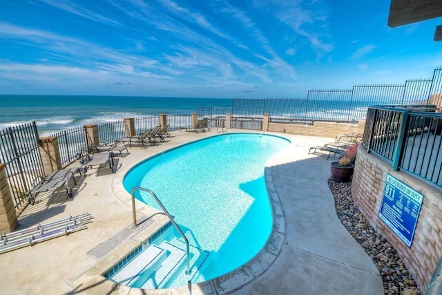 view of swimming pool with a patio area and a water view