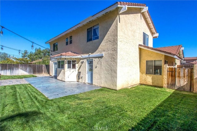 back of house with a yard and a patio area