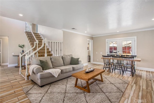 living room featuring crown molding, light hardwood / wood-style flooring, and french doors