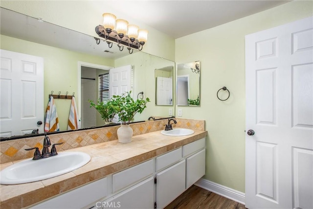 bathroom with vanity, wood-type flooring, and tasteful backsplash