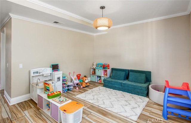 playroom with hardwood / wood-style floors and crown molding