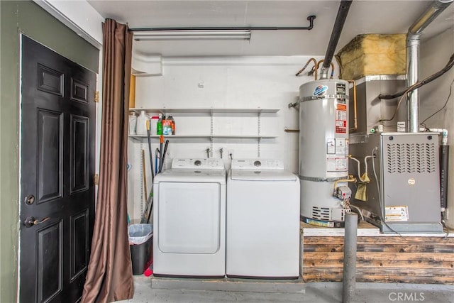 laundry area featuring washing machine and clothes dryer and strapped water heater