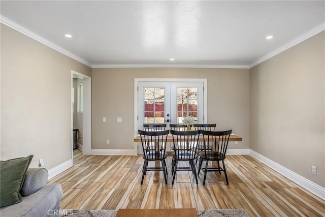 dining space featuring ornamental molding, light hardwood / wood-style flooring, and french doors