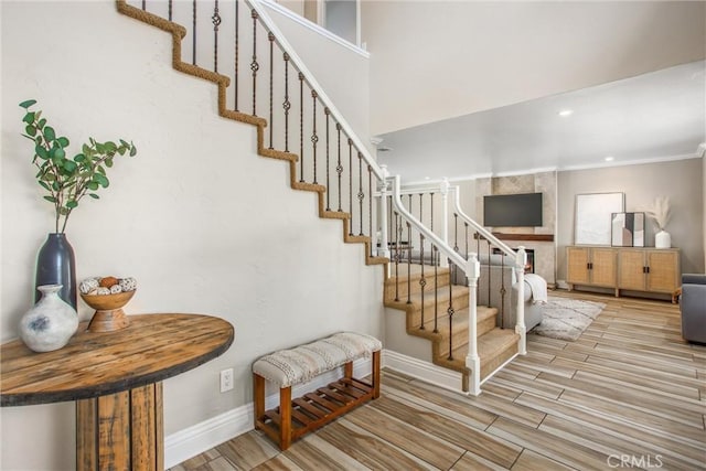 stairs featuring hardwood / wood-style flooring and crown molding