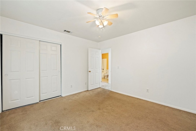 unfurnished bedroom featuring light carpet, a closet, and ceiling fan