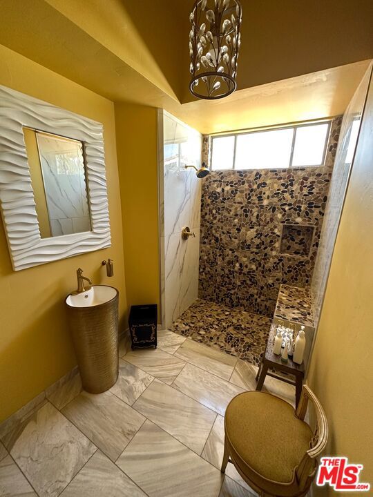 bathroom featuring an inviting chandelier and walk in shower