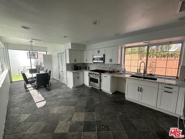 kitchen featuring appliances with stainless steel finishes, sink, and white cabinets