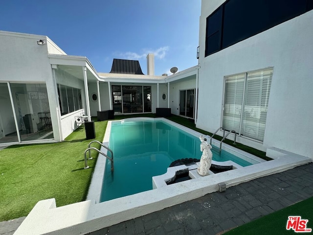 view of swimming pool with a yard