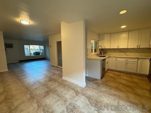 kitchen with white cabinetry, sink, stainless steel dishwasher, a wall mounted AC, and decorative backsplash