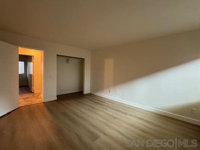 unfurnished bedroom with hardwood / wood-style floors and a closet