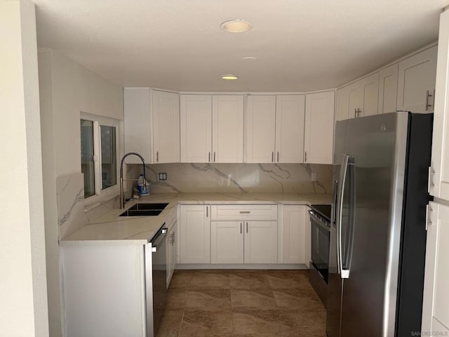 kitchen featuring light stone countertops, white cabinetry, sink, and appliances with stainless steel finishes