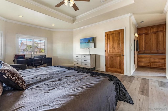 bedroom with light wood-type flooring, a raised ceiling, ceiling fan, and ornamental molding