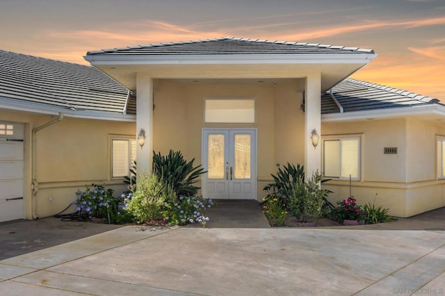 exterior entry at dusk featuring french doors