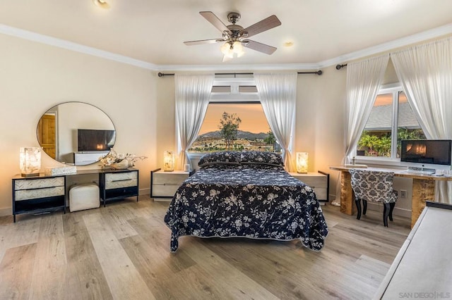 bedroom with ceiling fan, light wood-type flooring, and crown molding