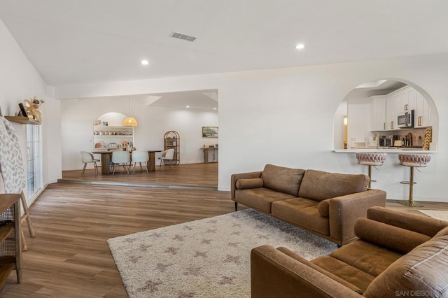 living room featuring dark hardwood / wood-style flooring and vaulted ceiling