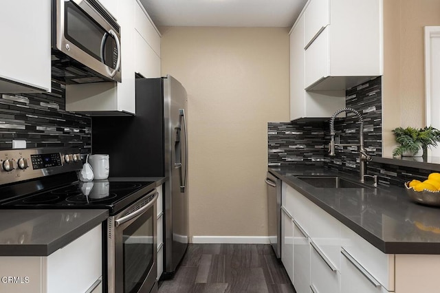 kitchen featuring white cabinets, appliances with stainless steel finishes, decorative backsplash, and sink