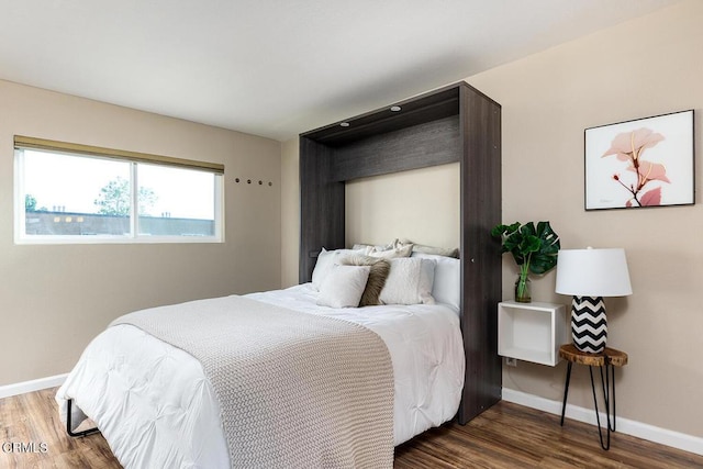 bedroom with dark hardwood / wood-style flooring