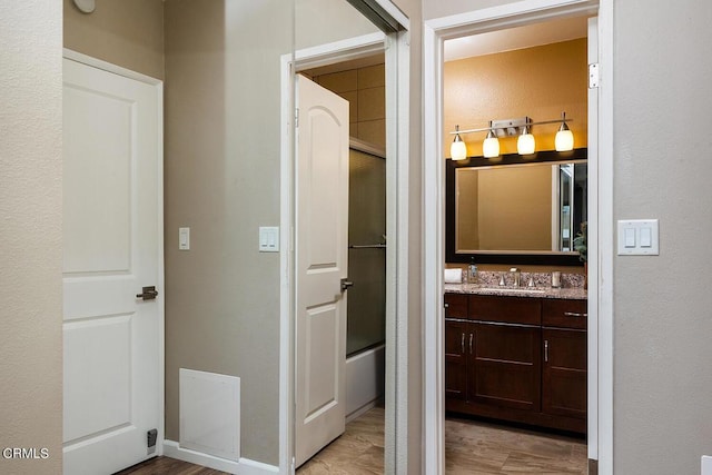 bathroom featuring vanity and combined bath / shower with glass door