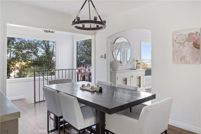 dining space featuring dark hardwood / wood-style flooring and an inviting chandelier