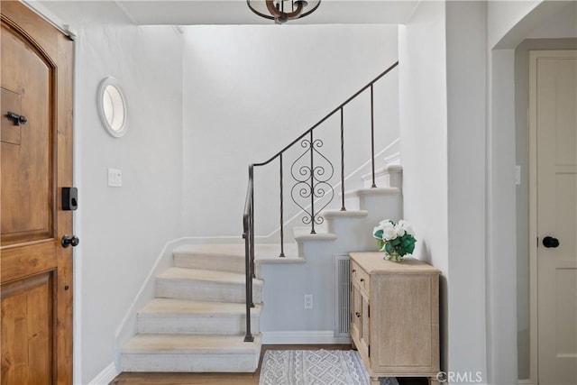 foyer featuring stairway, baseboards, and wood finished floors