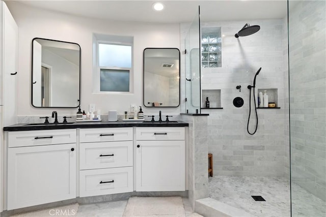 bathroom featuring tiled shower and vanity