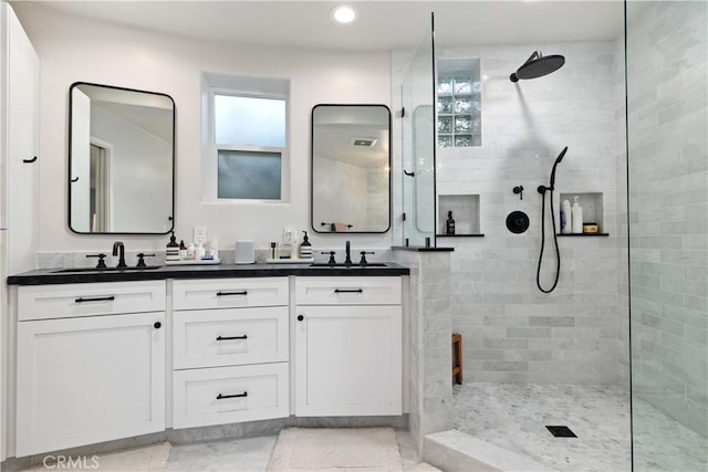 bathroom featuring recessed lighting, walk in shower, double vanity, and a sink