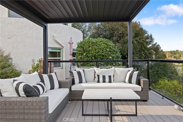 wooden terrace with an outdoor living space