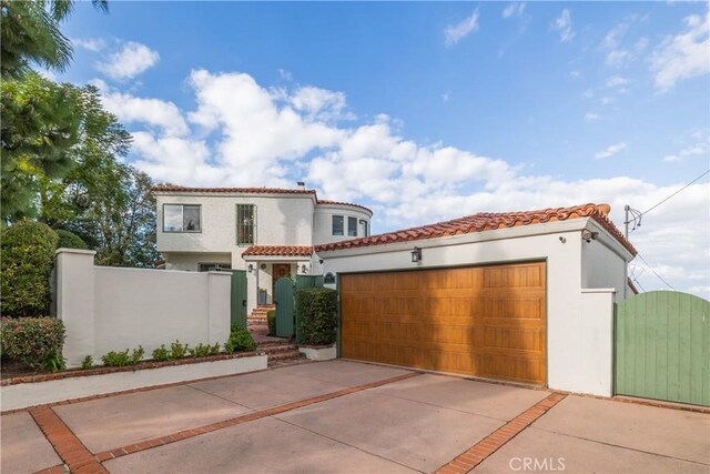 6401 Corsini Pl, Rancho Palos Verdes, CA 90275 - mediterranean / spanish-style home featuring a gate, a tile roof, stucco siding, and an attached garage