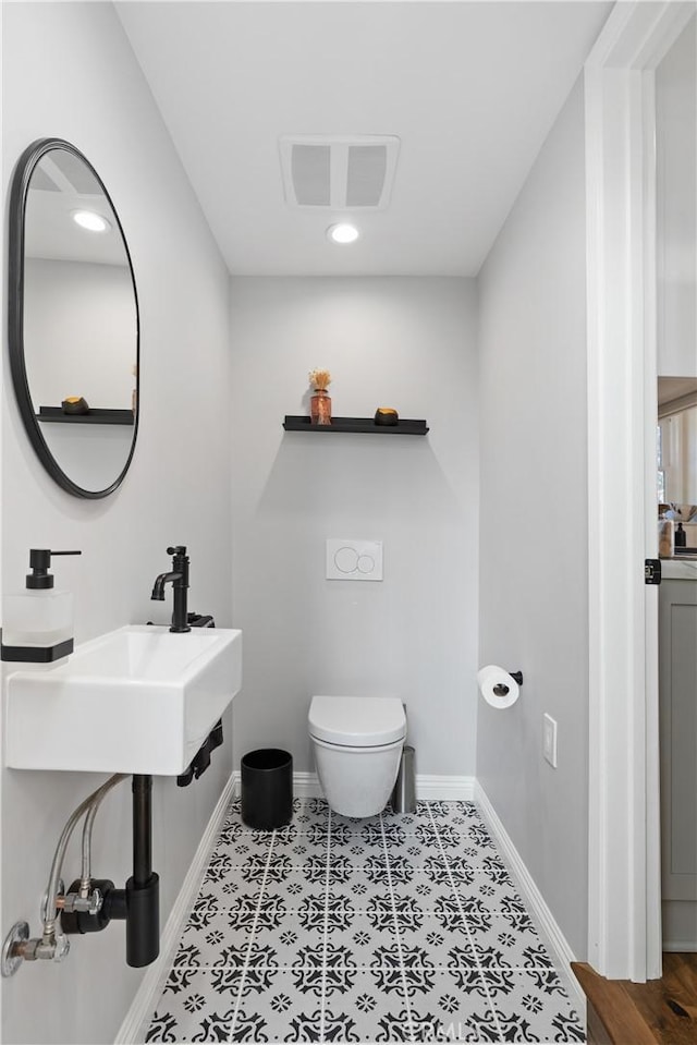half bath featuring toilet, visible vents, baseboards, and recessed lighting