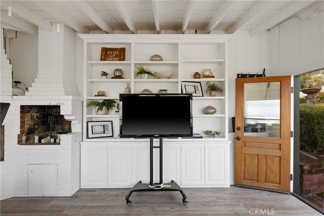 living area with wood finished floors and beam ceiling