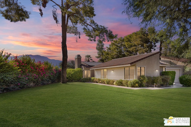 yard at dusk featuring a mountain view