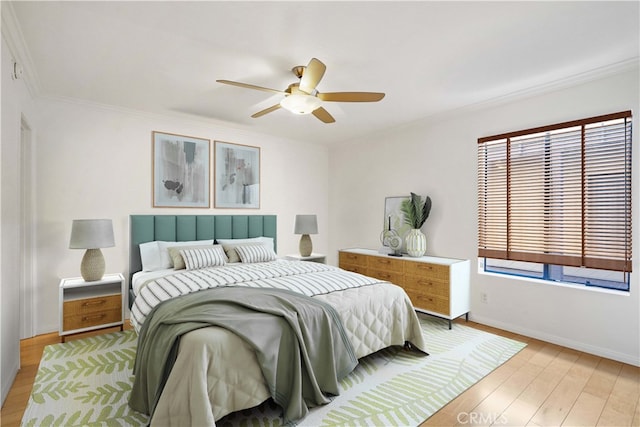 bedroom featuring light hardwood / wood-style floors, ornamental molding, and ceiling fan