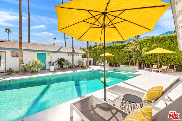 view of swimming pool featuring a patio area and an in ground hot tub