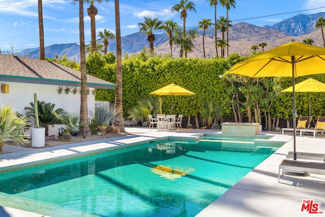 view of swimming pool featuring a patio area and a mountain view