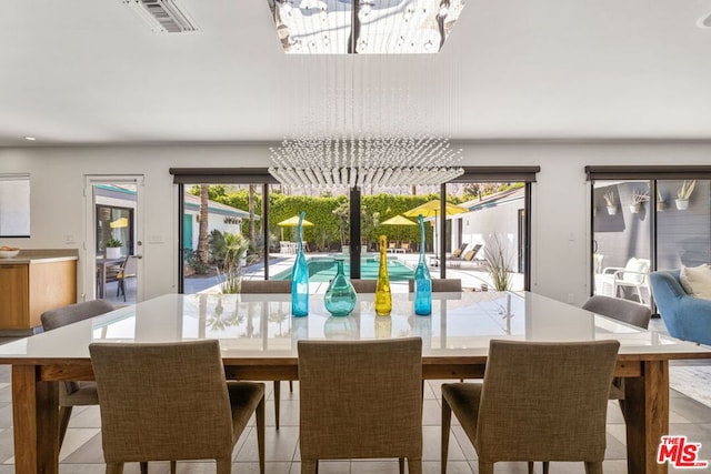 dining space with light tile patterned floors, a wealth of natural light, and a chandelier